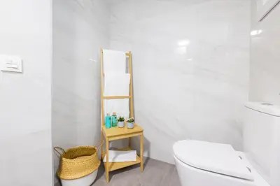 a white bathroom with a toilet and a wooden shelf at FLORIT FLATS - The Apolo Studio in Valencia
