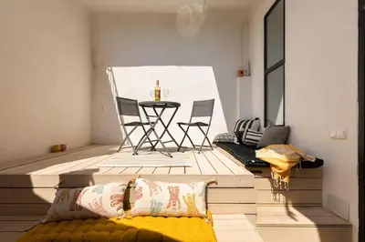 a living room with a table and chairs in a room at cozy loft patio+pool +wifi in Valencia