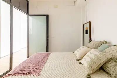 a bedroom with a bed with pillows and a mirror at cozy loft patio+pool +wifi in Valencia