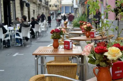 a row of tables and chairs with flowers on a street at Pequeño Loft en Ruzafa wifi in Valencia