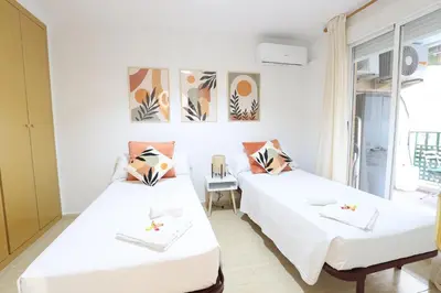 a room with two beds and a window at Adorable apartment 60m from the beach by Hometels in Puerto de Sagunto