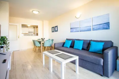 a living room with a blue couch and a table at ESPACIO 5 - Primera Línea de Playa in Cullera