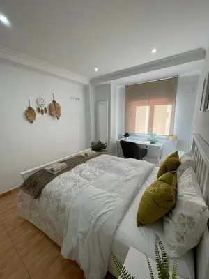 a bedroom with a large bed and a desk at UIM Mediterraneo Virgen del Carmen 1 Wifi in Puerto de Sagunto