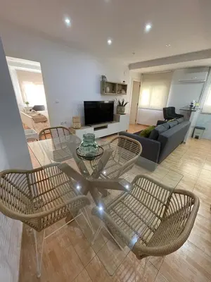 a living room with a glass table and chairs at UIM Mediterraneo Virgen del Carmen 1 Wifi in Puerto de Sagunto