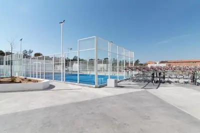 a glass building with a pool in front of it at Global Vacacional, Moderno apartamento con gran terraza y vistas al mar in Canet de Berenguer