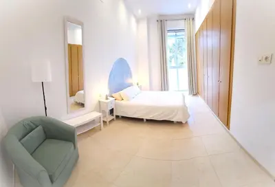 a white bedroom with a bed and a chair at BEACH VALENCIA LUXURY B40-7 Apartament on Beach in Valencia