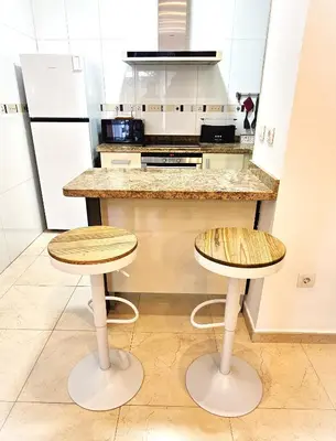 a kitchen with two stools in front of a counter at BEACH VALENCIA LUXURY B40-7 Apartament on Beach in Valencia