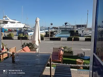 a patio with a table and an umbrella and a pool at Apartamento playa in Playa Pobla de Farnals
