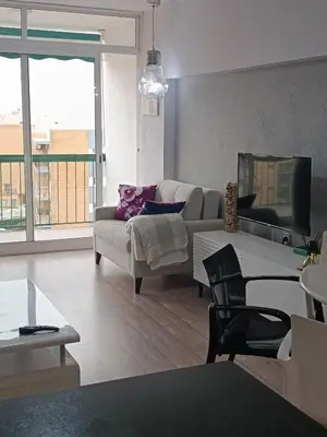 a living room with a couch and a tv at Apartamento playa in Playa Pobla de Farnals