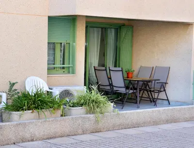 a patio with chairs and a table on a porch at Apartamento dos habitaciones primera línea de playa in Valencia