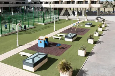 a park with benches and a playground in a building at Veramar Beach Apartment in Valencia