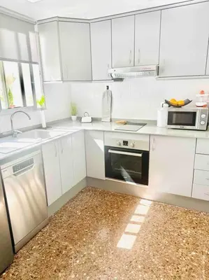 a white kitchen with a sink and a microwave at Citadella Apartment in Puerto de Sagunto