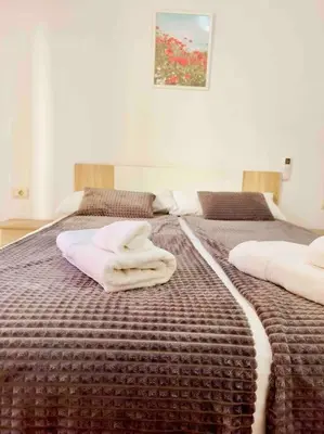 a bedroom with two beds with towels on them at Citadella Apartment in Puerto de Sagunto