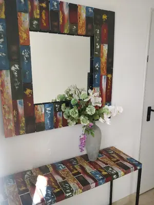 a vase of flowers on a table with a mirror at LA CASA AZUL de Anna in Anna