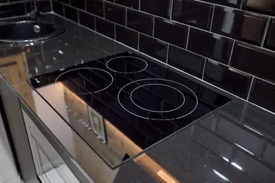 a stove top oven with black tiles on a counter at PR27 in Valencia