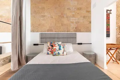a bedroom with a bed and a brick wall at PR27 in Valencia