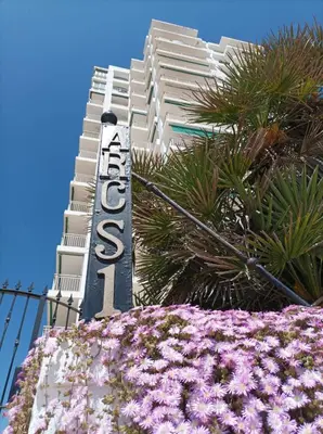 a hotel sign in front of a building with purple flowers at Almar Collection Cullera AR in Cullera