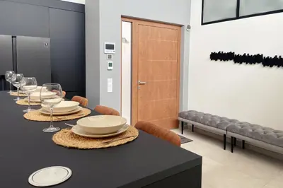 a dining room with a table with plates and wine glasses at Colina del Sol Penthouse Horizonte in Cullera