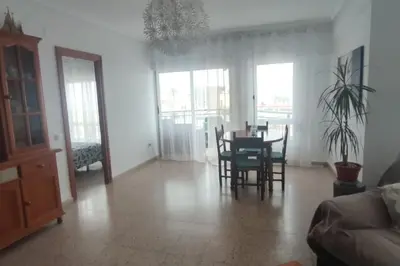 a living room with a dining room table and chairs at Apartamento 1ª línea de Playa in Puebla de Farnals