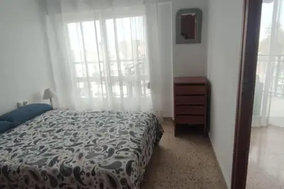 a bedroom with a bed and a dresser and a window at Apartamento 1ª línea de Playa in Puebla de Farnals