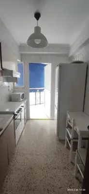 a kitchen with a refrigerator and a large window at Apartamento 1ª línea de Playa in Puebla de Farnals