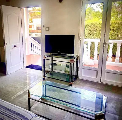 a living room with a tv and a glass table at Casa Las Emilias en La Cañada in Partida de La Cañada