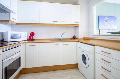 a kitchen with white cabinets and a sink and a microwave at ESPACIO 18 - Primera Línea de Playa in Cullera