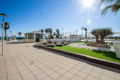 a park with palm trees and a building at ESPACIO 18 - Primera Línea de Playa in Cullera