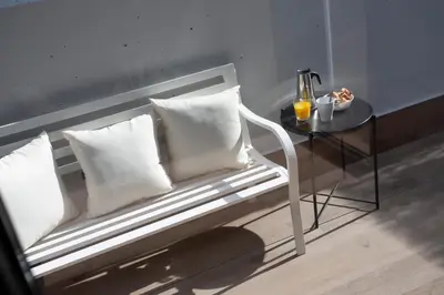 a bench with two pillows and a table with a side table at SingularStays Arena in Valencia