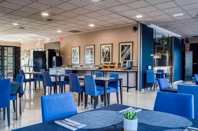 a room with a blue wall with a bed and a lamp at Hotel Ignacio - PalomarGroup in Chiva