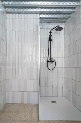 a shower in a room with white tiled walls at Estudio Baleares Apartamento n3 in Valencia