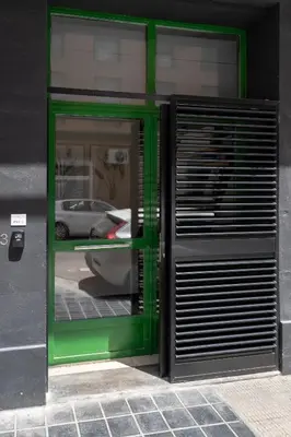 a green door with a car reflection in a window at Estudio Baleares Apartamento n3 in Valencia