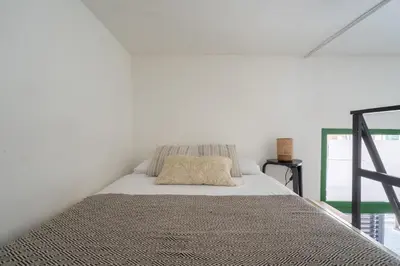 a bed in a room with a white wall at Estudio Baleares Apartamento n3 in Valencia