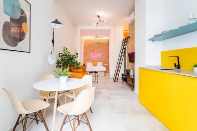 a kitchen and dining room with a white table and chairs at CHARMING LOFT IN RUZAFA, SOHO b2 in Valencia