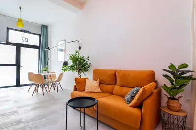 a living room with an orange couch and a table at CHARMING LOFT IN RUZAFA, SOHO b2 in Valencia