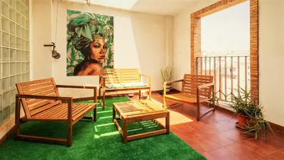 a balcony with a table and chairs and a painting at Penthouse Duplex in a 4 floors spanish house -8 min to center by Metro in Valencia