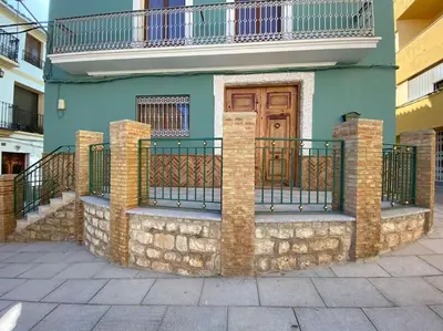 a house with a balcony and a wooden door at La Carchata in Siete Aguas