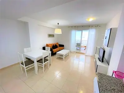 a living room with a couch and a table and a tv at Apartamento Grao de Moncofar REF. 041 in Moncófar