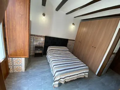 a large bed in a room with wooden cabinets at La carchata 1 in Siete Aguas