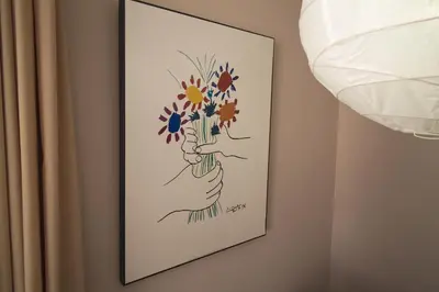 a picture of a hand holding flowers on a wall at Apartamentos Plaza Picasso in Valencia