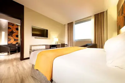 a hotel room with a large bed and a television at Exe Puerto de Sagunto in Puerto de Sagunto