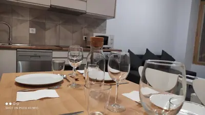 a table with wine glasses and plates on it at APARTMENTSUITESPAIN PLAYA - UNIVERSIDADes in Valencia