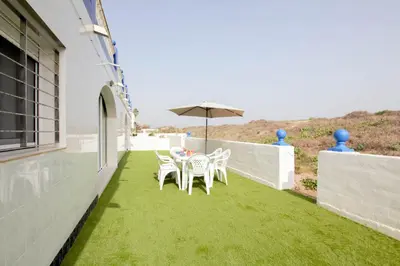 a patio with a table and chairs and an umbrella at Apartamento a pie de playa in Cullera