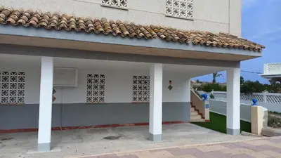 a building with white columns and a roof at Apartamento a pie de playa in Cullera