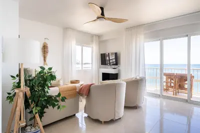 a living room with a couch and chairs and a balcony at El Acuario - Primera línea y todas las ventanas dan al mar in Cullera