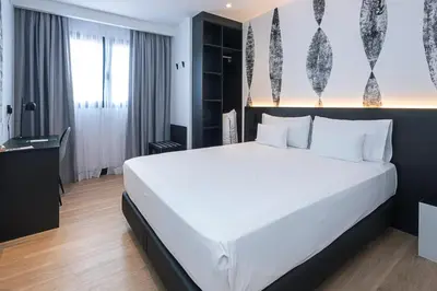 a bedroom with a large white bed in a room at Sercotel Plana Suites in Vall de Uixó