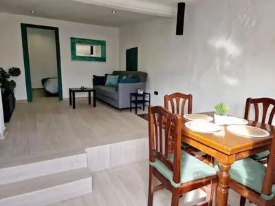 a dining room and living room with a table and chairs at APARTAMENTO CON TERRAZA Y BARBACOA in Paterna