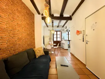 a living room with a couch and a brick wall at Apartamento con encanto histórico in Valencia
