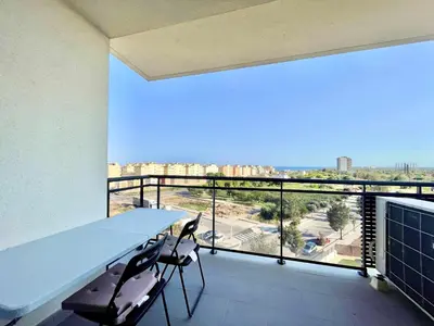 a balcony with a table and chairs and a large window at Apartamento con piscina, padel y vistas al mar in Moncófar