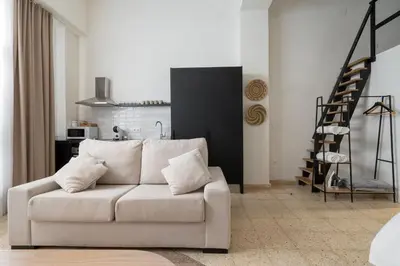 a living room with a white couch and a staircase at Loft Ibiza Apartamento n2 in Valencia